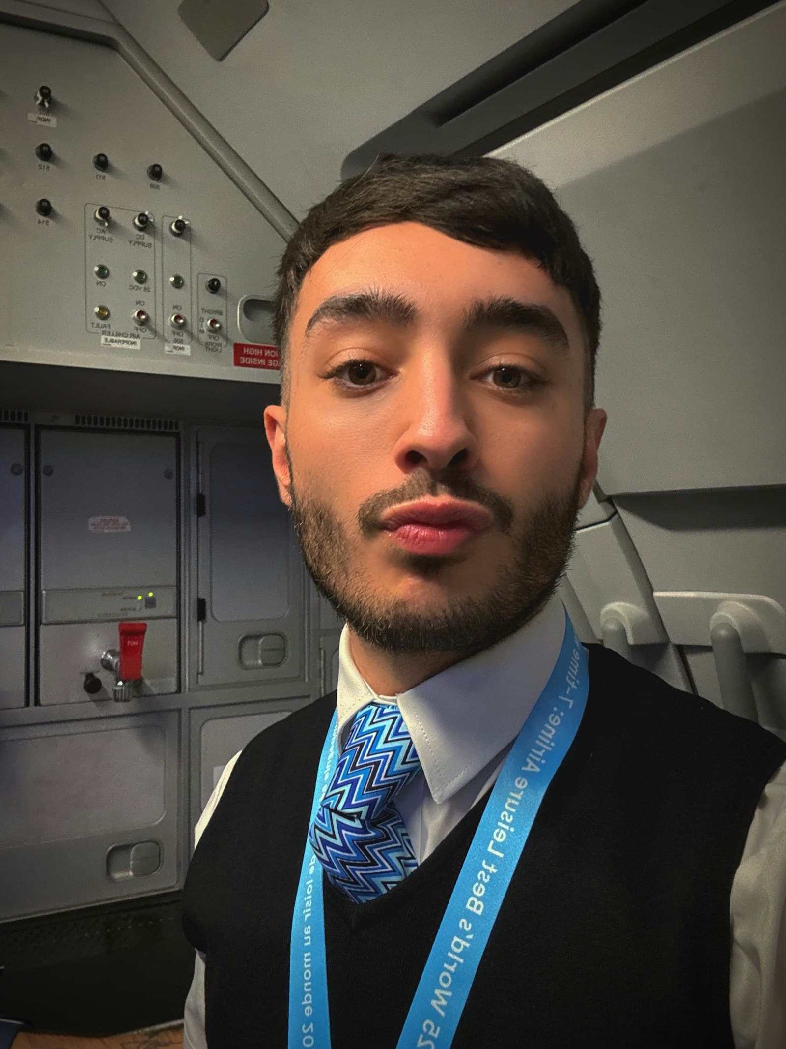 Cabin crew member smiling, mid-conversation with a member.