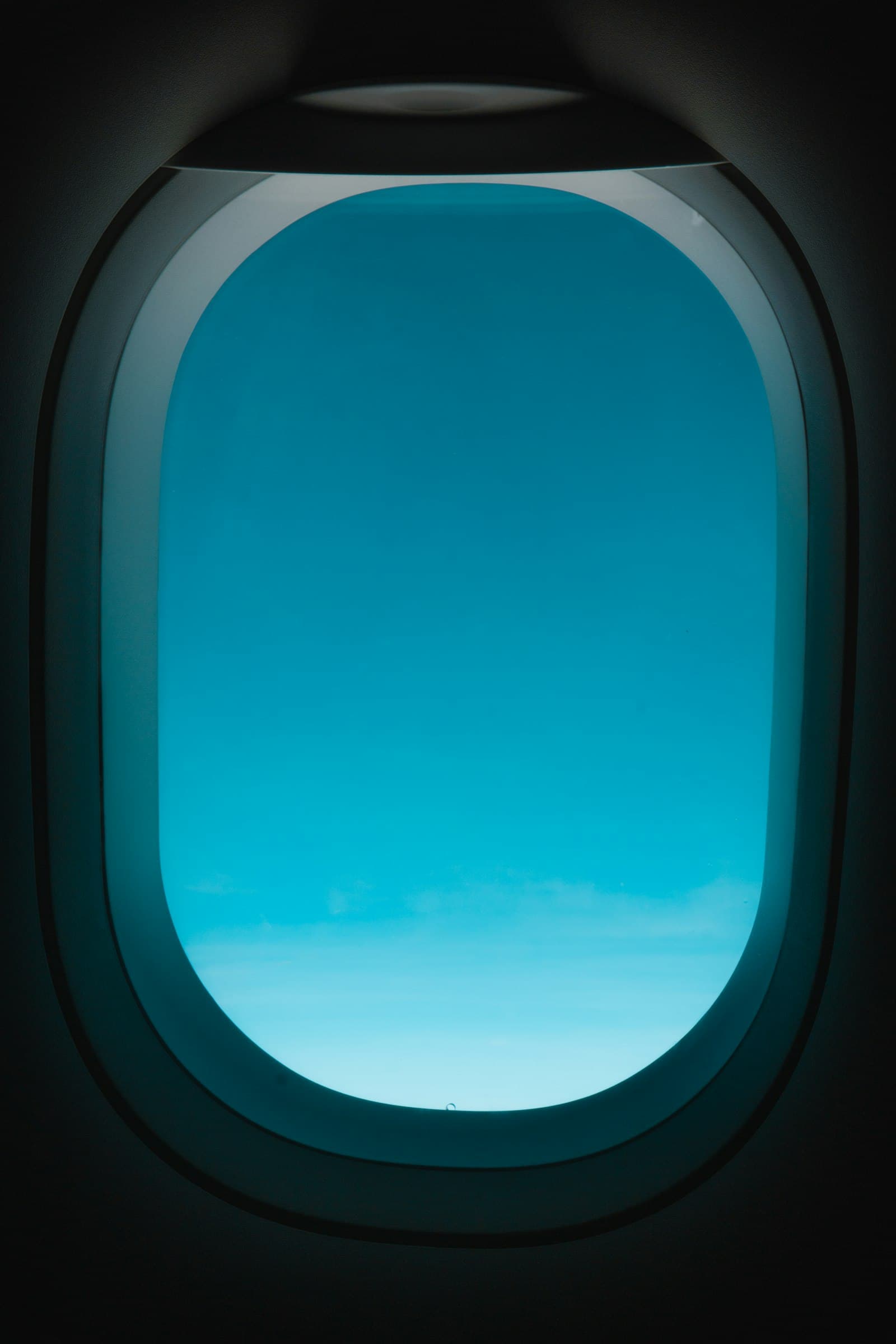 A single passenger seated by the cabin window, no one in the seats around them.