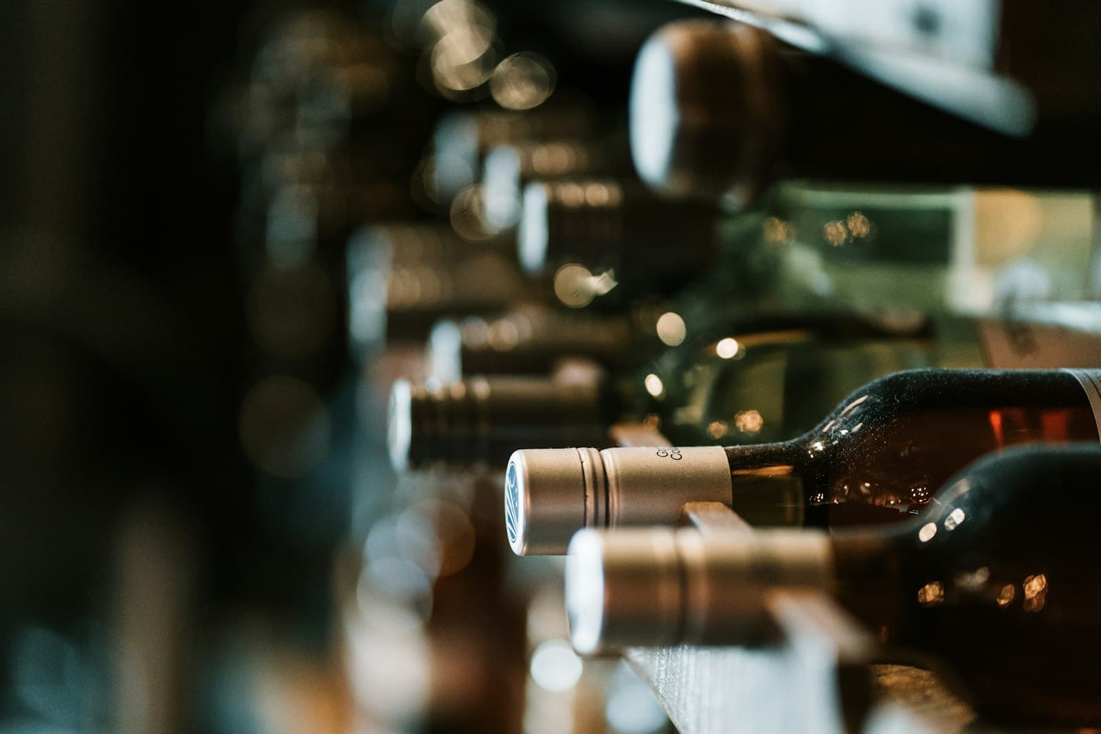 Wine bottles laid out in a dimly lit cellar, candlelight.
