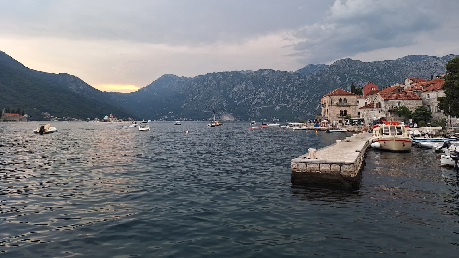 Superyachts moored in the calm Bay of Kotor at sunset.